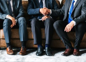 Kolme juristia istuu vierekkäin, kasvoja ei näy, joku on valittava