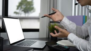 Henkilö istuu työpisteellä mietteliäänä ja arvioi työhön liittyvää päätöstä tai ongelmaa.